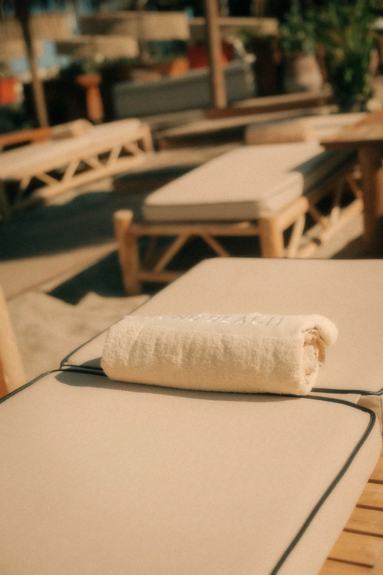 Opgerolde strandhanddoek op een comfortabel ligbed